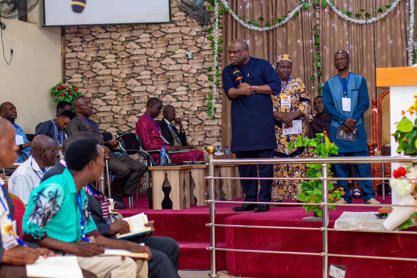 A pastor and church leaders standing before a seated congregation