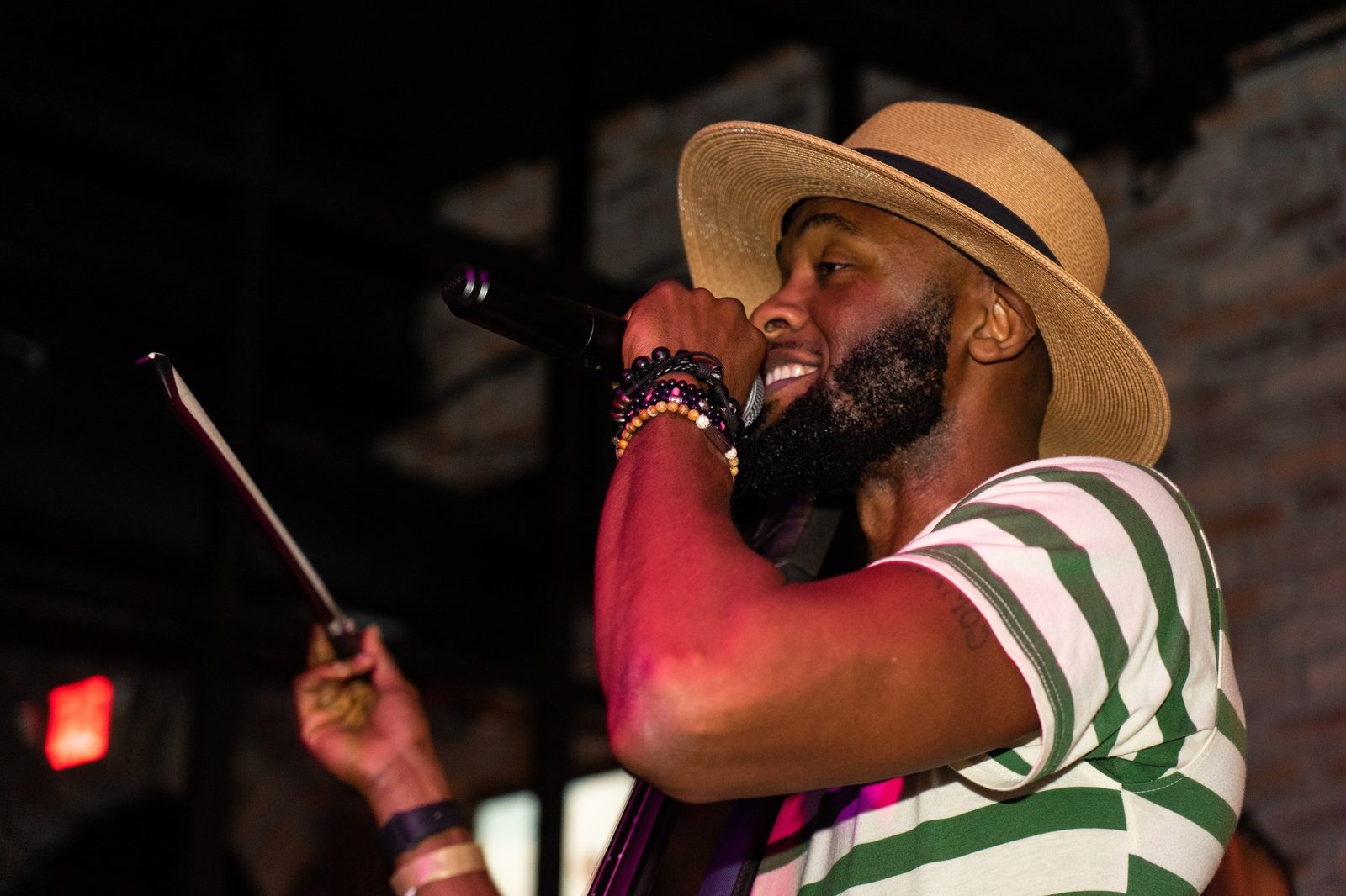 A singer in a straw hat performing on stage